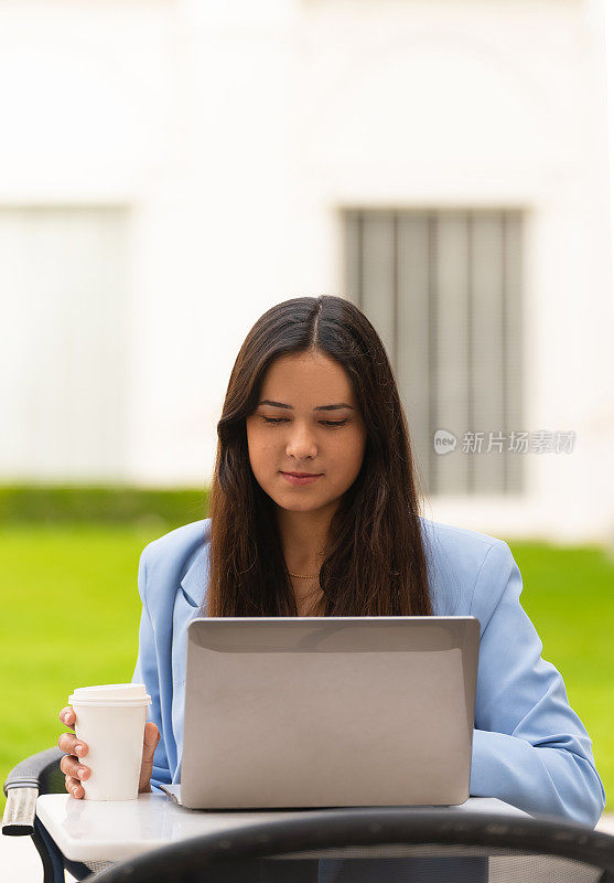 European businesswoman working on a laptop in a café